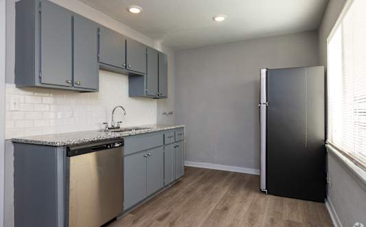 A kitchen with a black stove top and a black refrigerator. at Blacklark Apartments, Apartments, Kansas City, KS