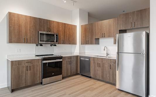 A modern kitchen with wooden cabinets and stainless steel appliances.