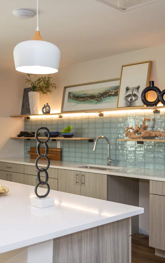A modern kitchen with a white countertop and stainless steel appliances.
