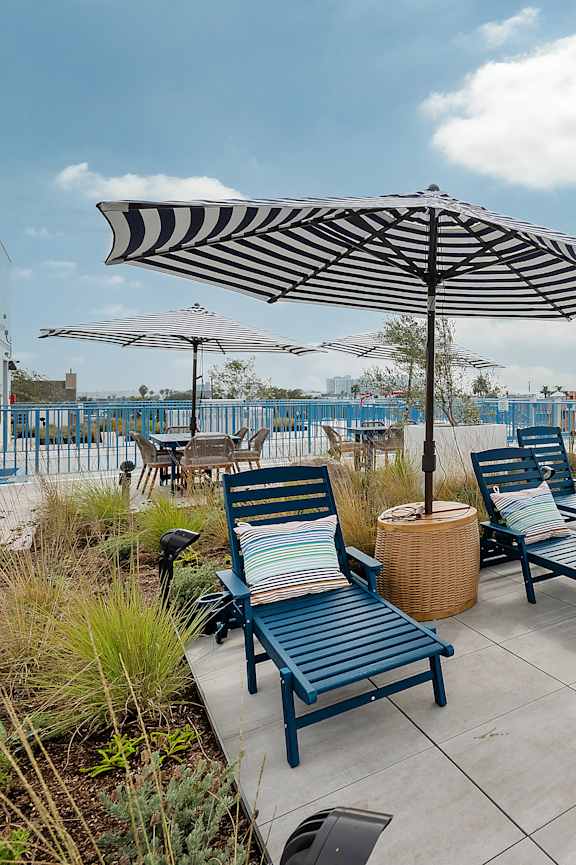 A rooftop patio with a striped awning and a staircase.