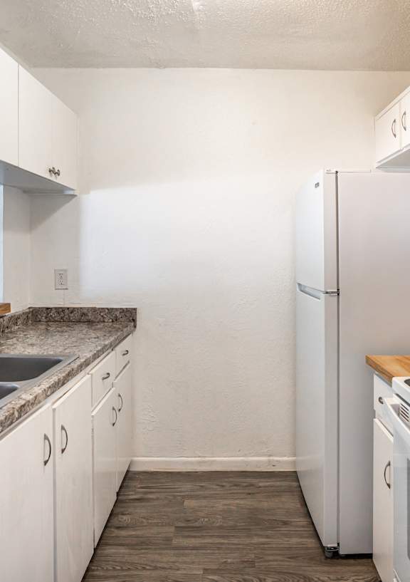 A kitchen with white appliances and wooden countertops.
