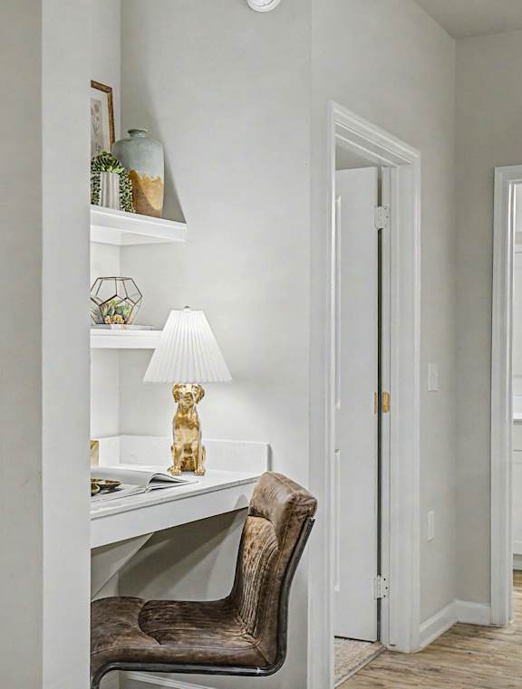 A room with a chair, a table, and a mirror.