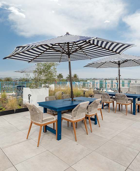 A rooftop patio with a striped awning and a staircase.