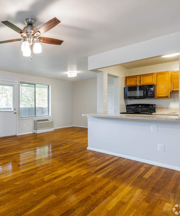 A room with wooden floors and a ceiling fan.