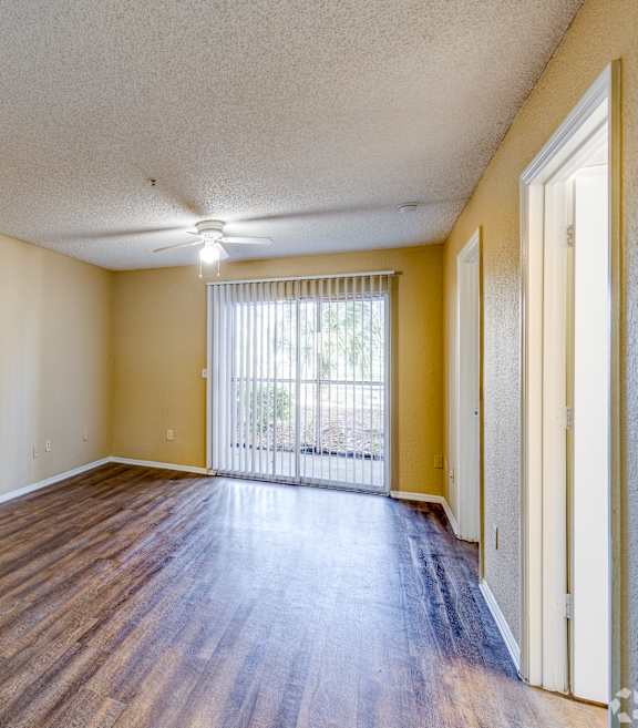 A room with wooden floors and a sliding glass door.