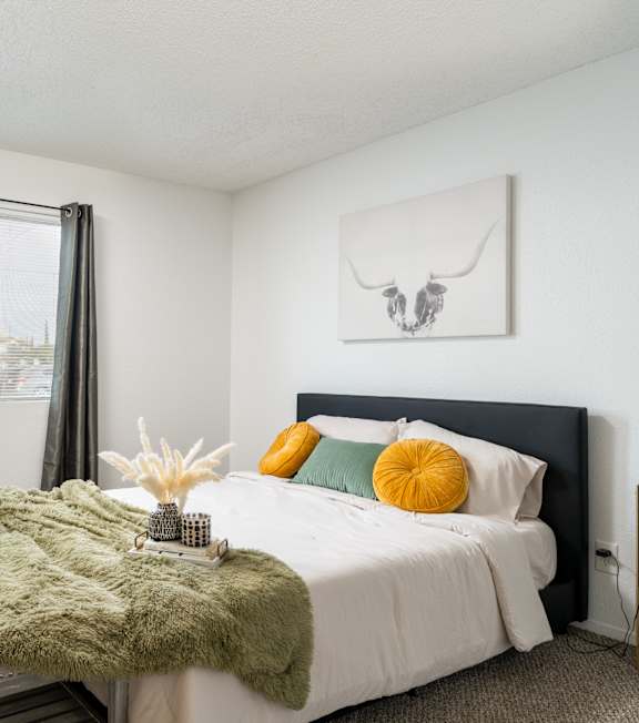 A bedroom with a large bed and a green blanket.