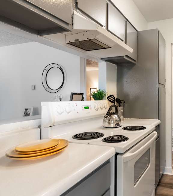 A modern kitchen with white appliances and wooden floors.