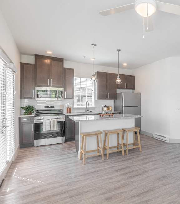 A modern kitchen with wooden floors and a white ceiling.