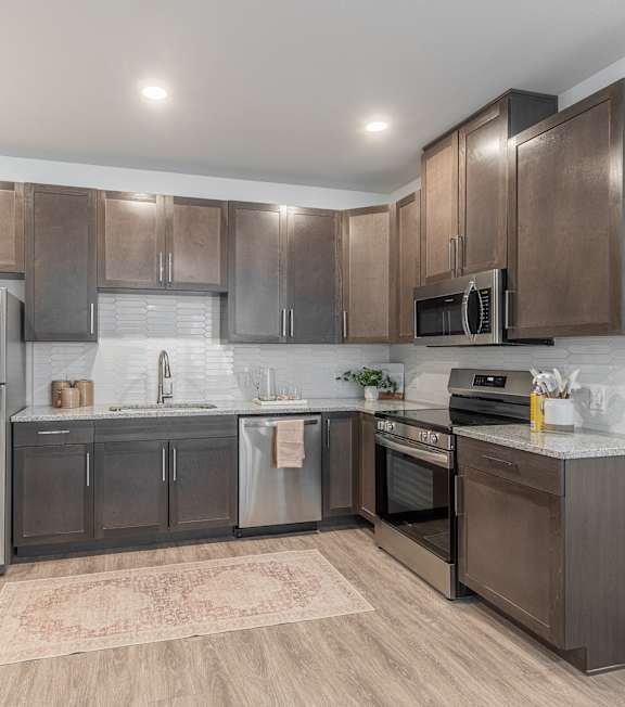 A modern kitchen with stainless steel appliances and wooden cabinets.