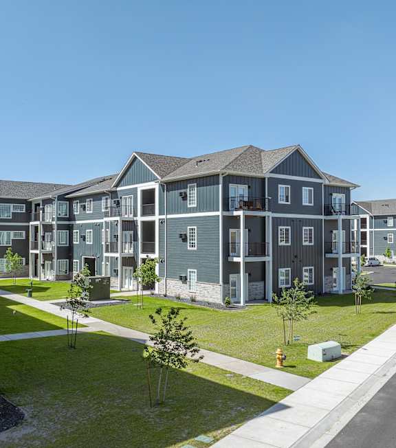 A row of modern townhouses with a clear blue sky above.