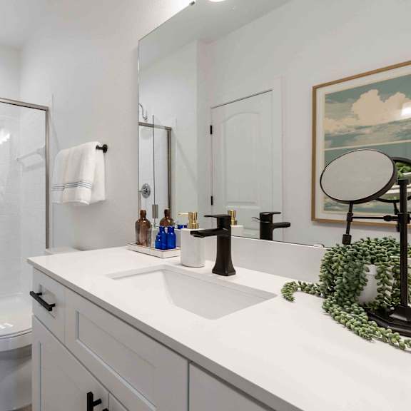 A white bathroom with a white toilet and a white sink.