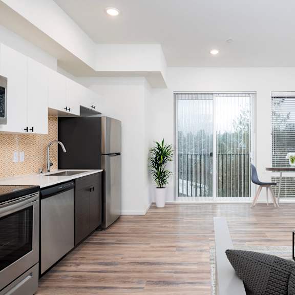 a kitchen with stainless steel appliances and a door to a balcony  at The Loop at Green Lake, Seattle, Washington