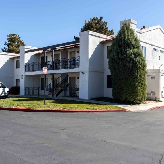 a white apartment building with a parking lot