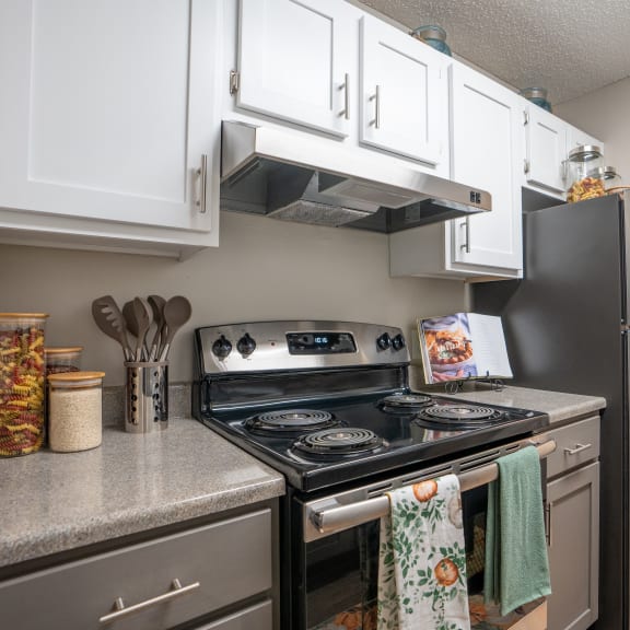 an updated kitchen with stainless steel appliances and white cabinets