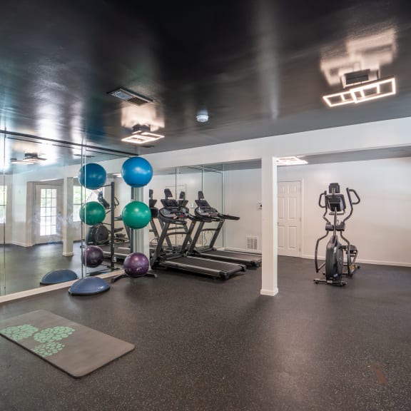a fitness room with exercise equipment and mirrors on the wall