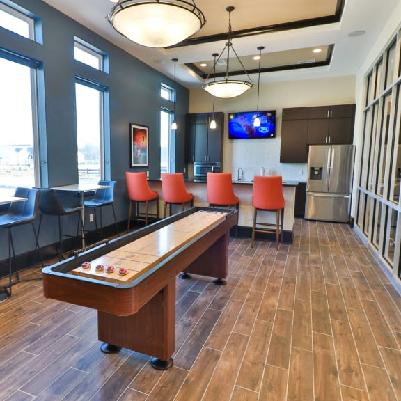 a game room with a pool table and chairs