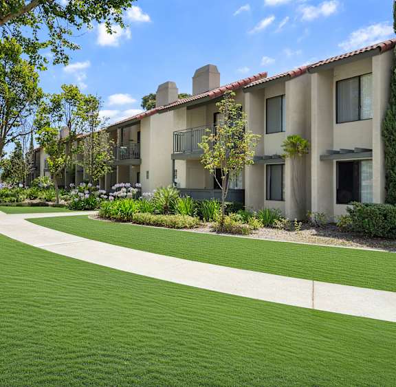 A grassy area in front of apartment buildings.