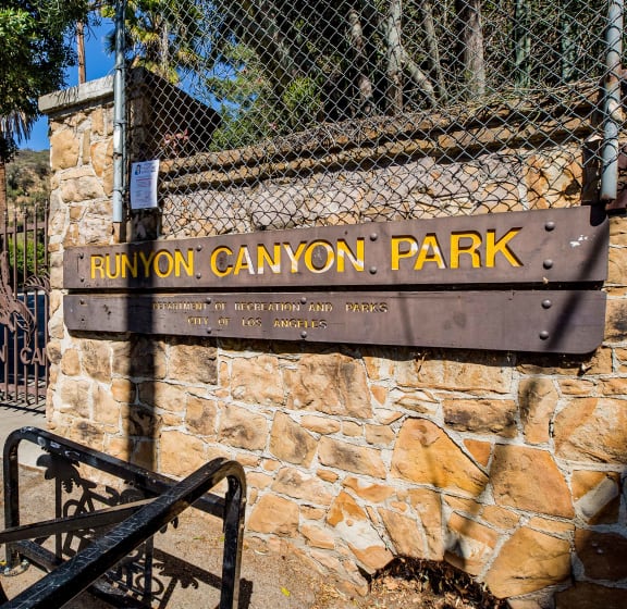 a sign for run on canyon park on a stone wall next to a gate