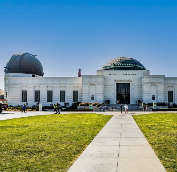 a large white building with two observatories on top of it and a green lawn