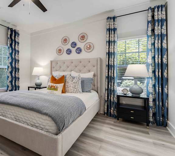 A bedroom with a large bed and a ceiling fan.