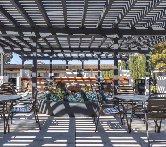 a patio with tables and chairs and a pergola