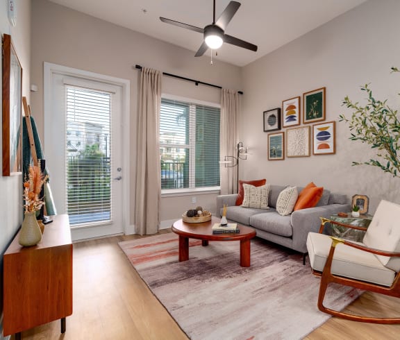 a wicker chair next to a curtain with a plant at The Haven at Lake Britt Apartments, Winter Garden, FL 34787