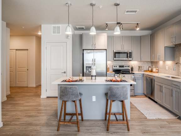 an open kitchen with a large island with two stools