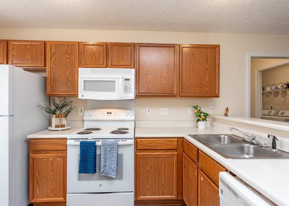 A kitchen with wooden cabinets and white appliances.