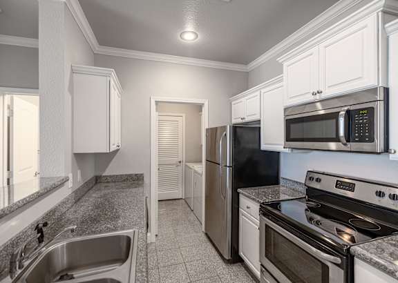 a kitchen with white cabinets and a granite counter top