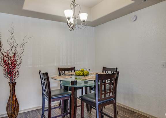 A dining room with a glass table and chairs.