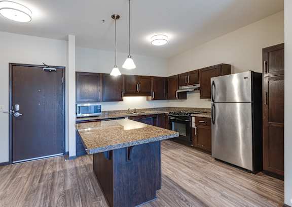 A kitchen with a granite countertop and stainless steel appliances.