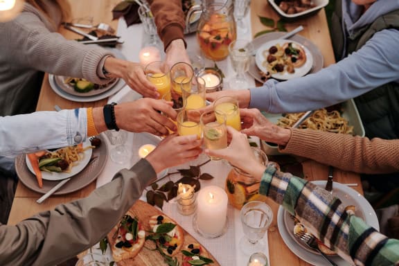 a group of people toast their glasses over a dinner table