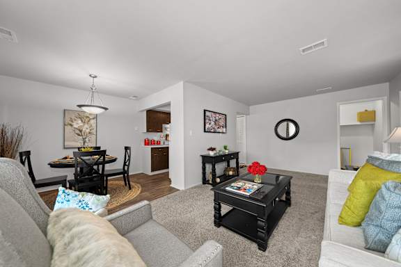 A living room with a grey couch and a black coffee table.