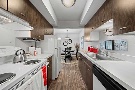 A modern kitchen with a white stove top oven and a white dishwasher.
