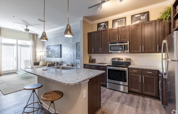 an open kitchen and living room with a granite counter top