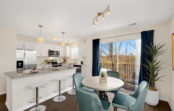 a living room with a kitchen and a table with chairs at Mainstreet Village, Novi, MI