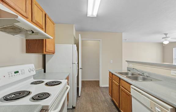 A kitchen with a white stove top oven and a white refrigerator.