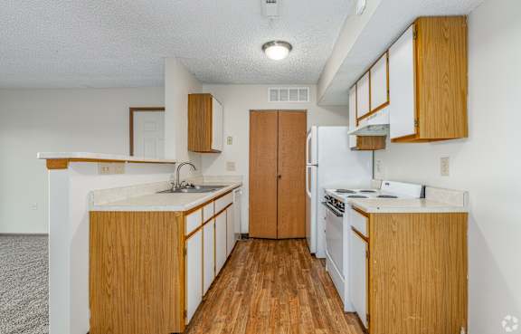 A kitchen with wooden cabinets and a white counter.