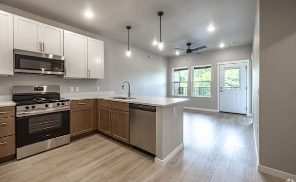 A modern kitchen with wooden cabinets and stainless steel appliances.