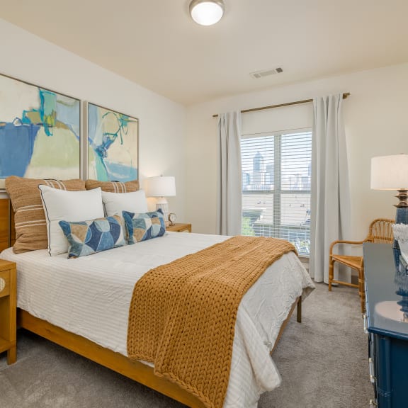 a bedroom with a bed and a dresser and a window
