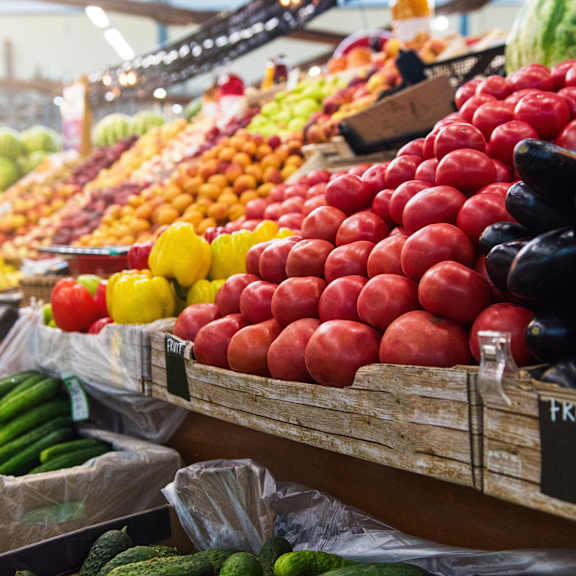 A fruit stand with a variety of fruits including apples, oranges, and watermelons.