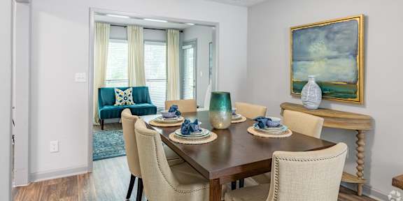 A dining room with a wooden table and chairs.