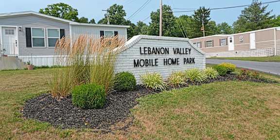 A sign that says Lebanon Valley Mobile Home Park in front of some homes.
