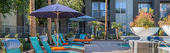 A row of blue chairs are lined up on a patio.