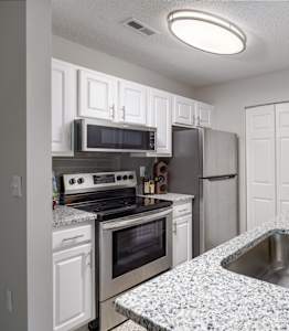 Modern apartment kitchen's with stainless steel appliances and granite countertops at Waters Edge at Harbison