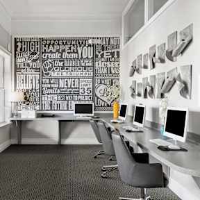 A white kitchen with a bar area and chairs.