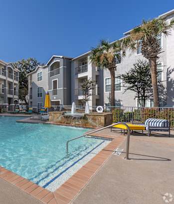 A swimming pool surrounded by apartment buildings.