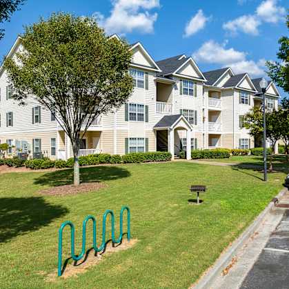 an apartment building with a green park in front of it