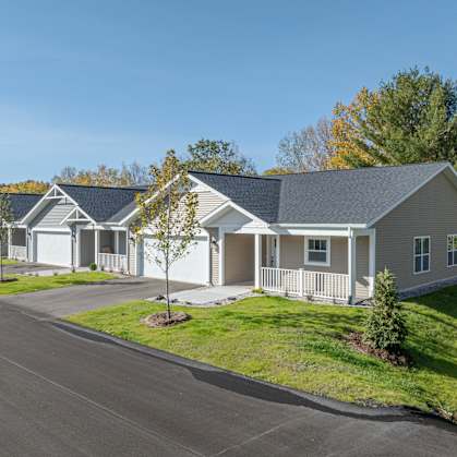A row of houses with a tree in front of the first house.