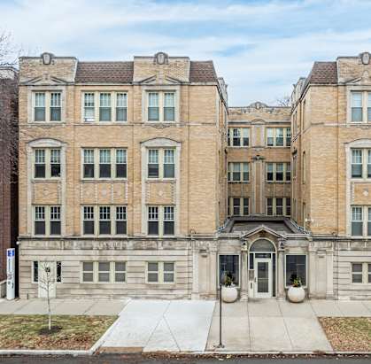 A large, two-story building with a central entrance and a symmetrical facade.